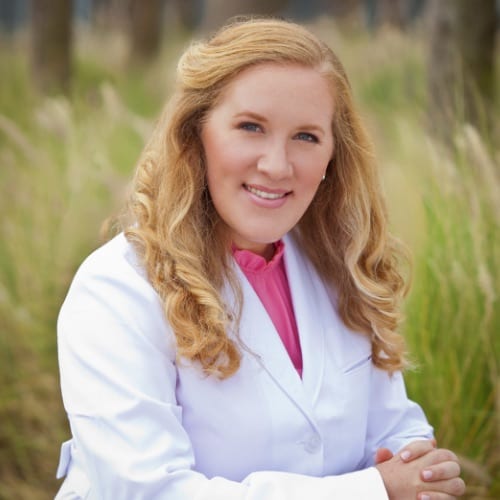 Dr. Joyce sitting outside in a lab coat