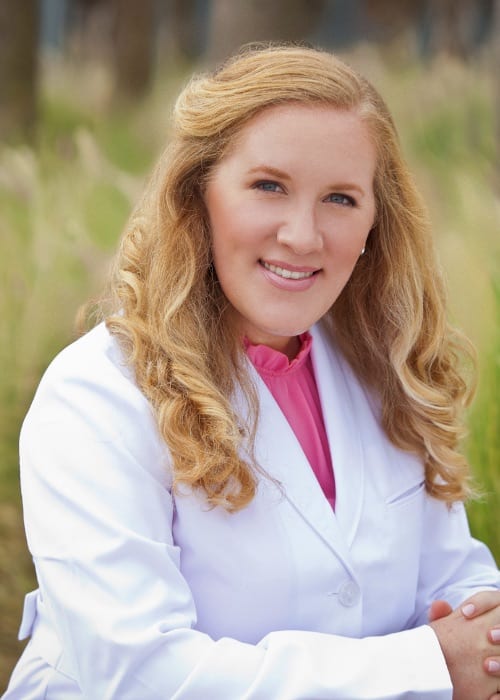 Dr. Joyce sitting outside in a lab coat